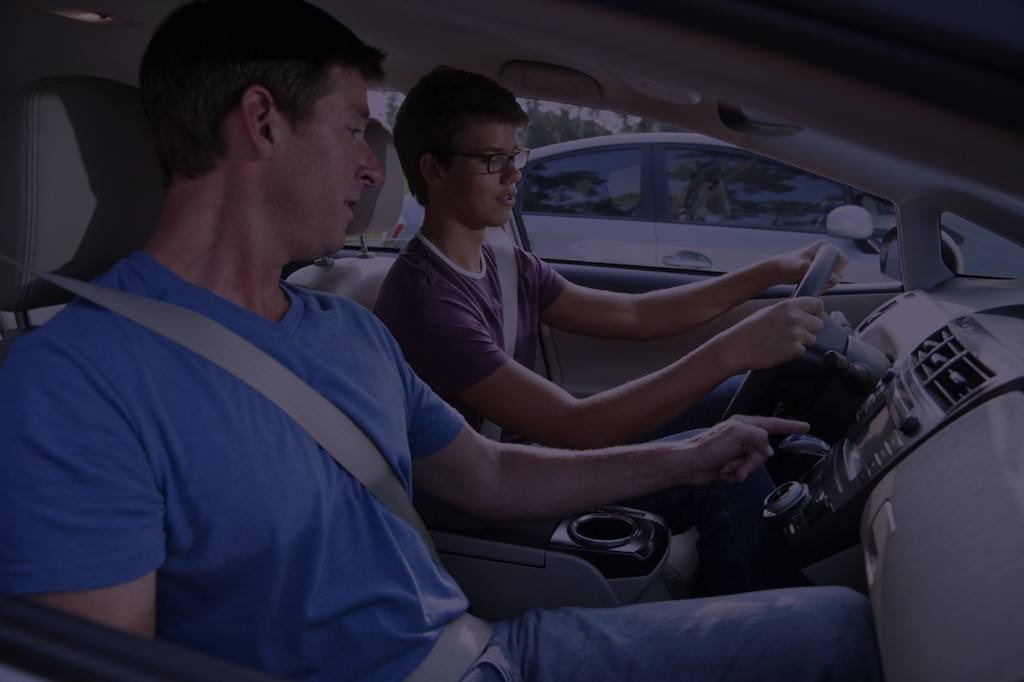 Parent guiding a new driver during a practice session